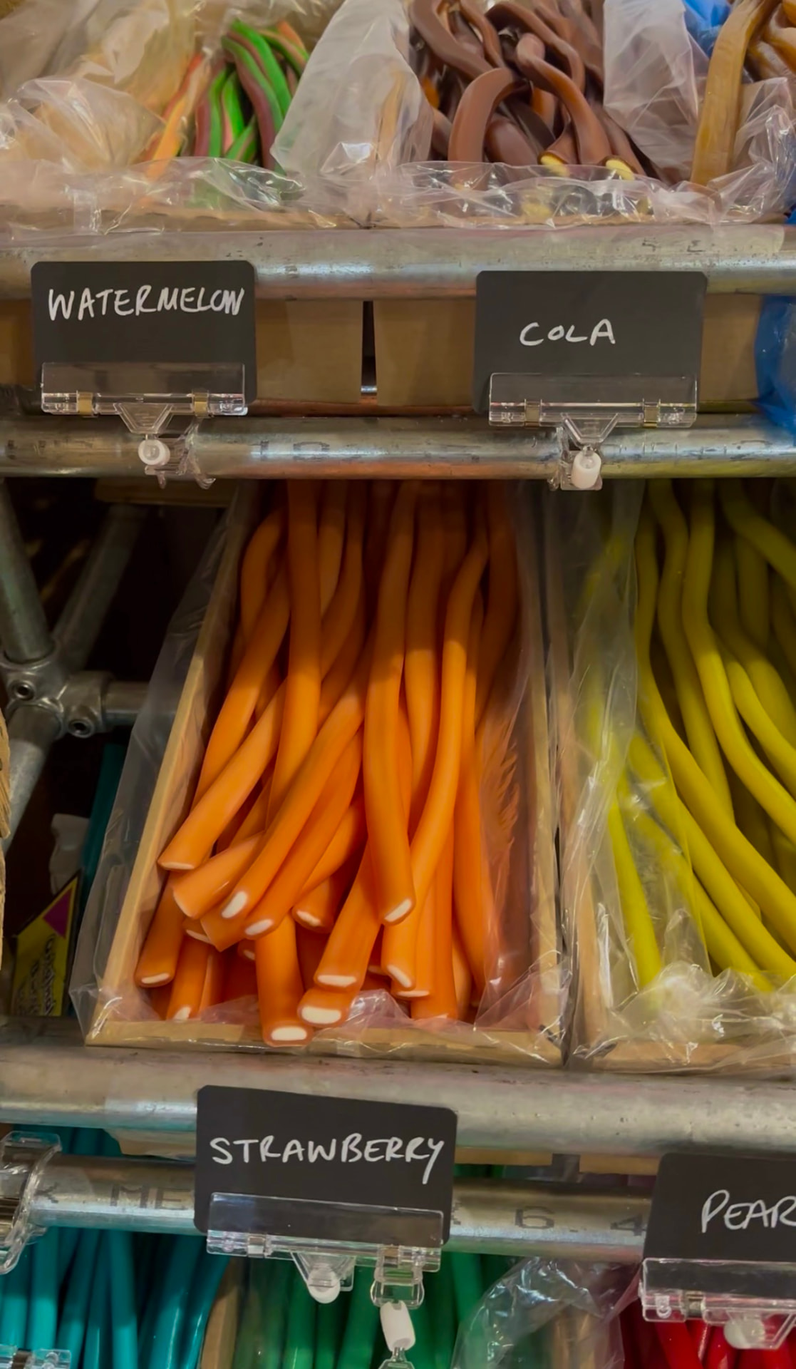 Watermelon, cola and strawberry liquorice cables in wooden crates.